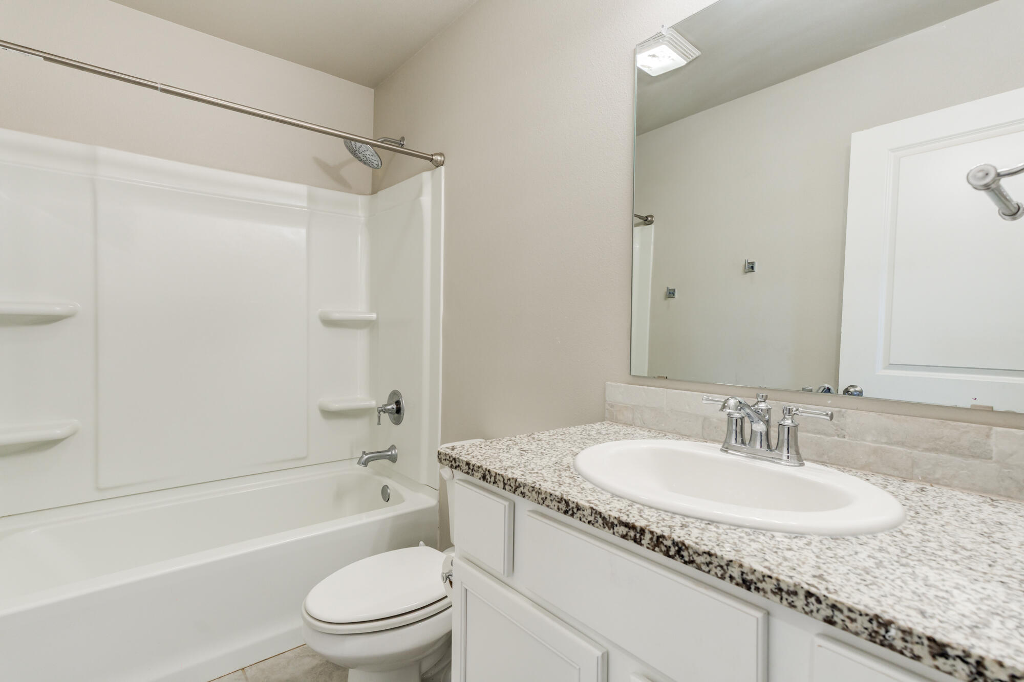 7429 31st Street Lubbock, TX 79407 - Photo 25 of 29 a bathroom with a granite countertop sink toilet and shower