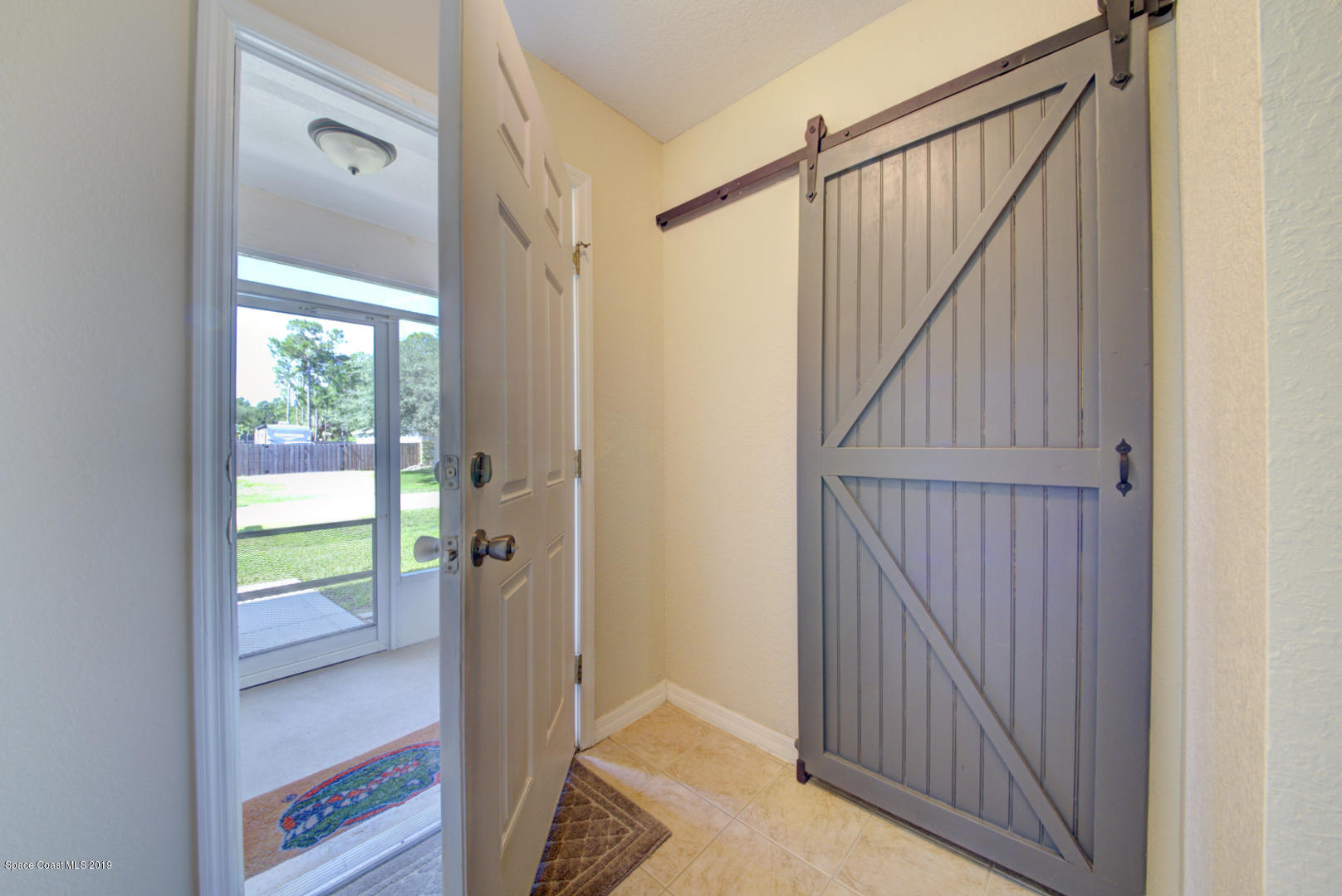 419 Hamer Road Southwest Palm Bay, FL 32908 - Photo 4 of 33 foyer with barn door to bedroom 4