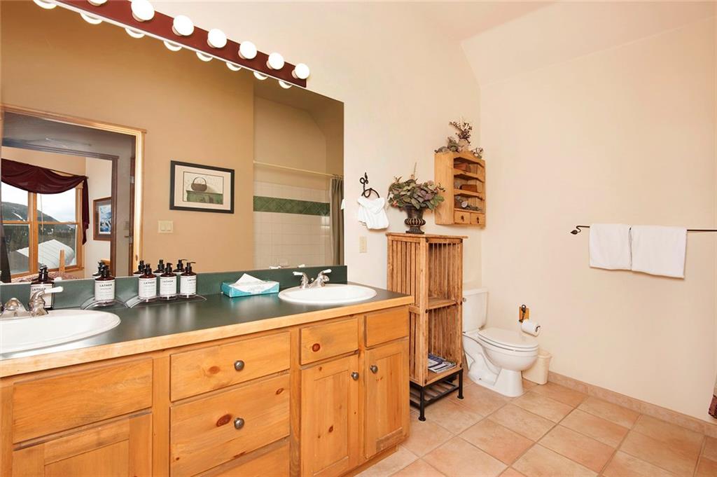 129 River Run Road, Unit 8071 Keystone, CO 80435 - Photo 14 of 21 a bathroom with a toilet a sink and mirror