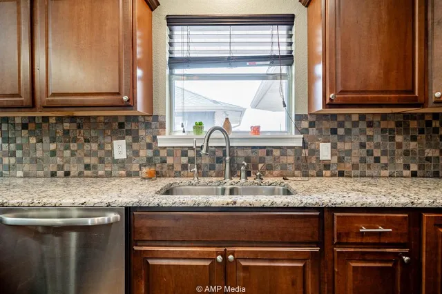 a kitchen with granite countertop cabinets sink and window