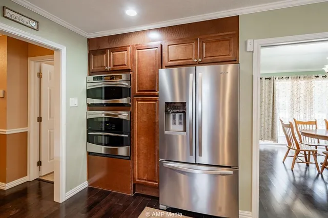 a metallic refrigerator freezer sitting in a kitchen