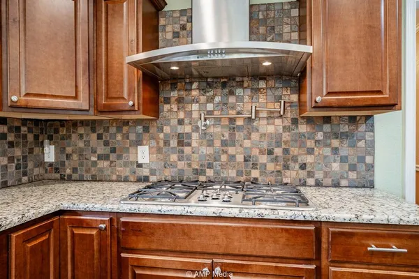 a kitchen with granite countertop a sink and a stove