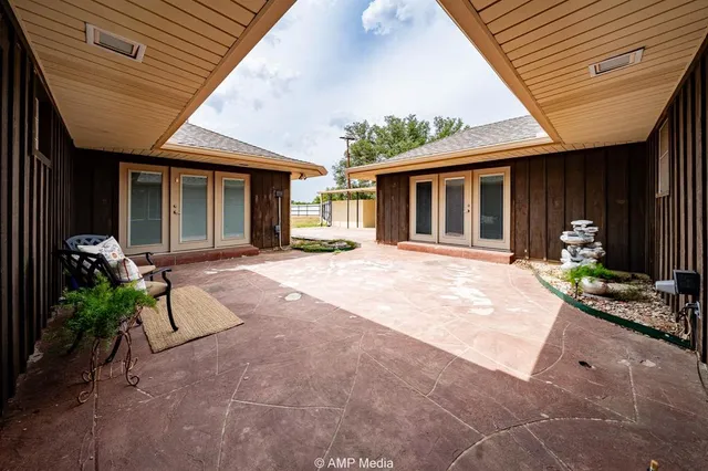 a view of a patio with table and chairs under an umbrella