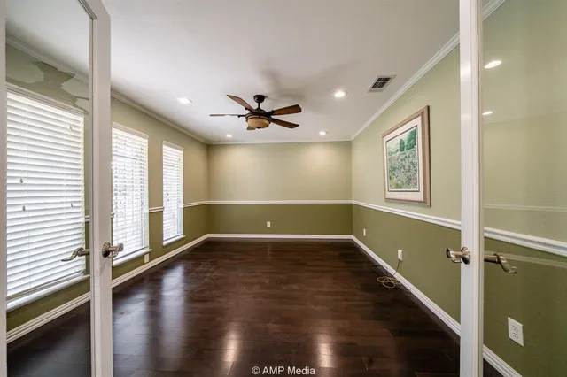 a view of an empty room with a window and wooden floor