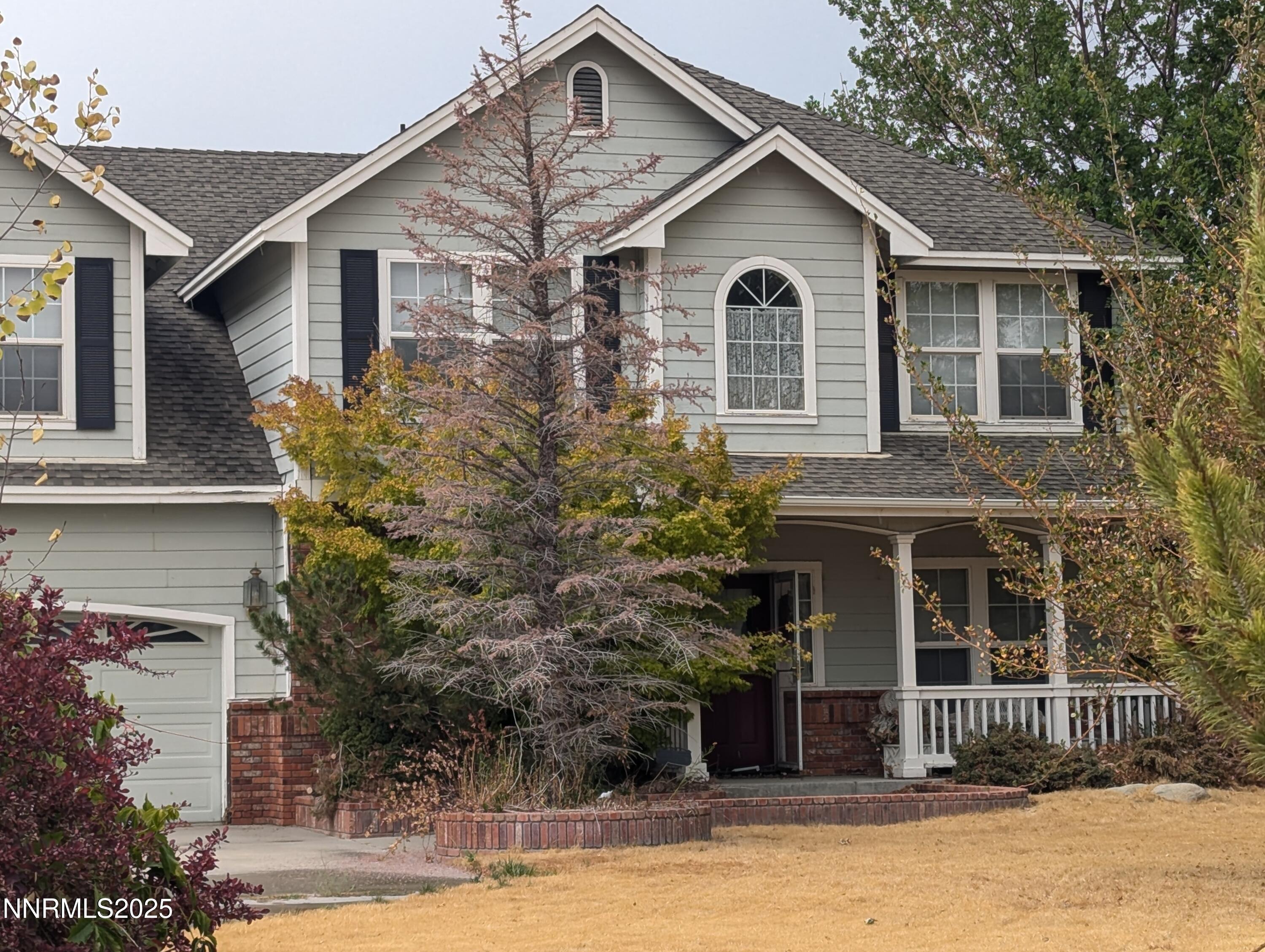 1248 Pleasantview Drive Gardnerville, NV 89460 - Photo 5 of 5 a view of a white house with large windows and a yard with plants