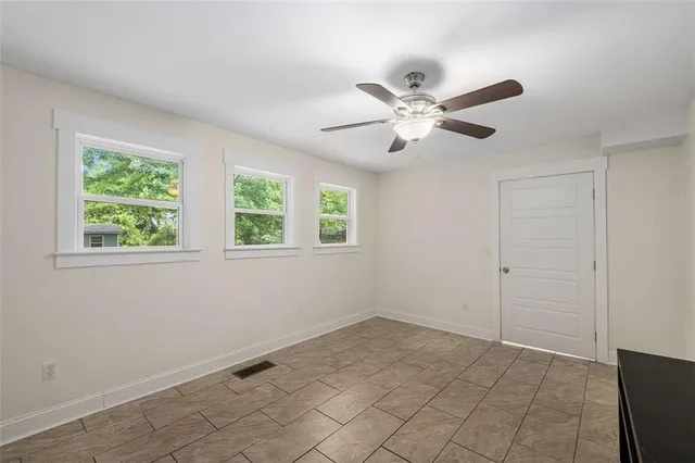 a view of an empty room with a ceiling fan and a window