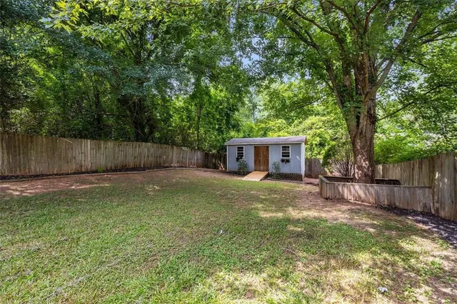 a view of a backyard with a trees and wooden fence