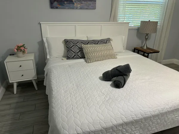 a bedroom with a bed and a white cabinet