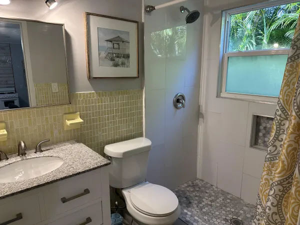 a bathroom with a granite countertop toilet a sink and a mirror