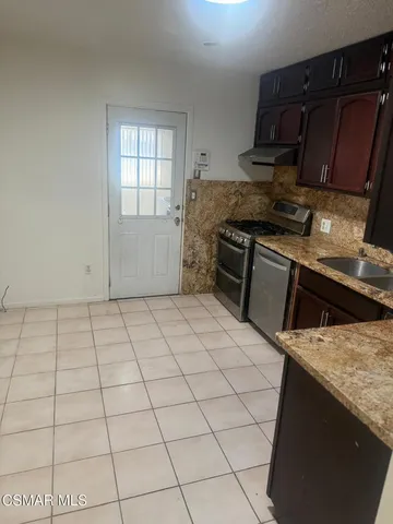 a kitchen with a stove a sink and cabinets