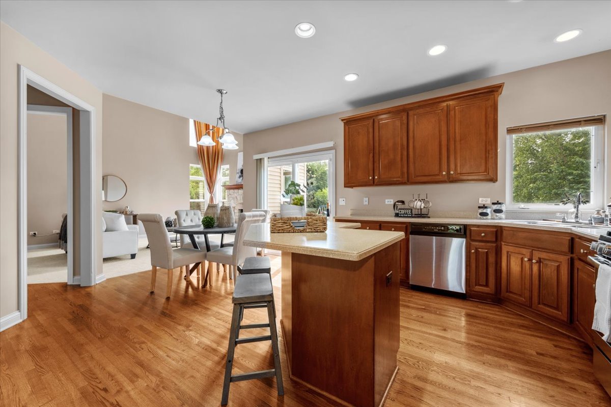 1112 Stonehaven Circle Aurora, IL 60504 - Photo 4 of 28 a kitchen with granite countertop a stove a sink a dining table and chairs