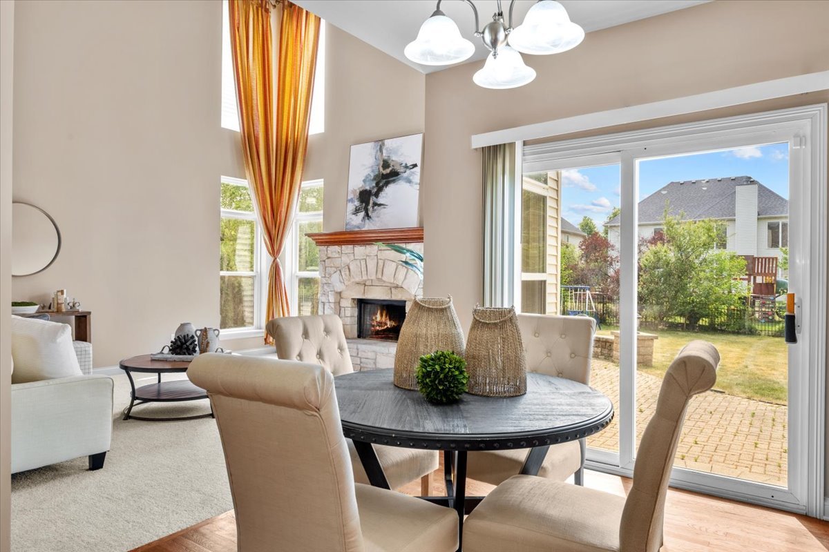 1112 Stonehaven Circle Aurora, IL 60504 - Photo 6 of 28 a living room with furniture a chandelier and a fireplace