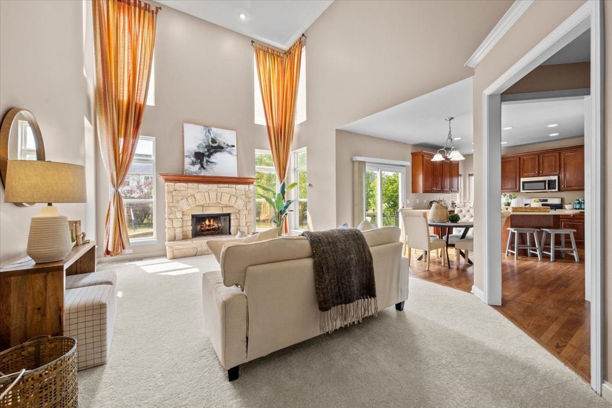 1112 Stonehaven Circle Aurora, IL 60504 - Photo 7 of 28 a living room with furniture a fireplace and a floor to ceiling window