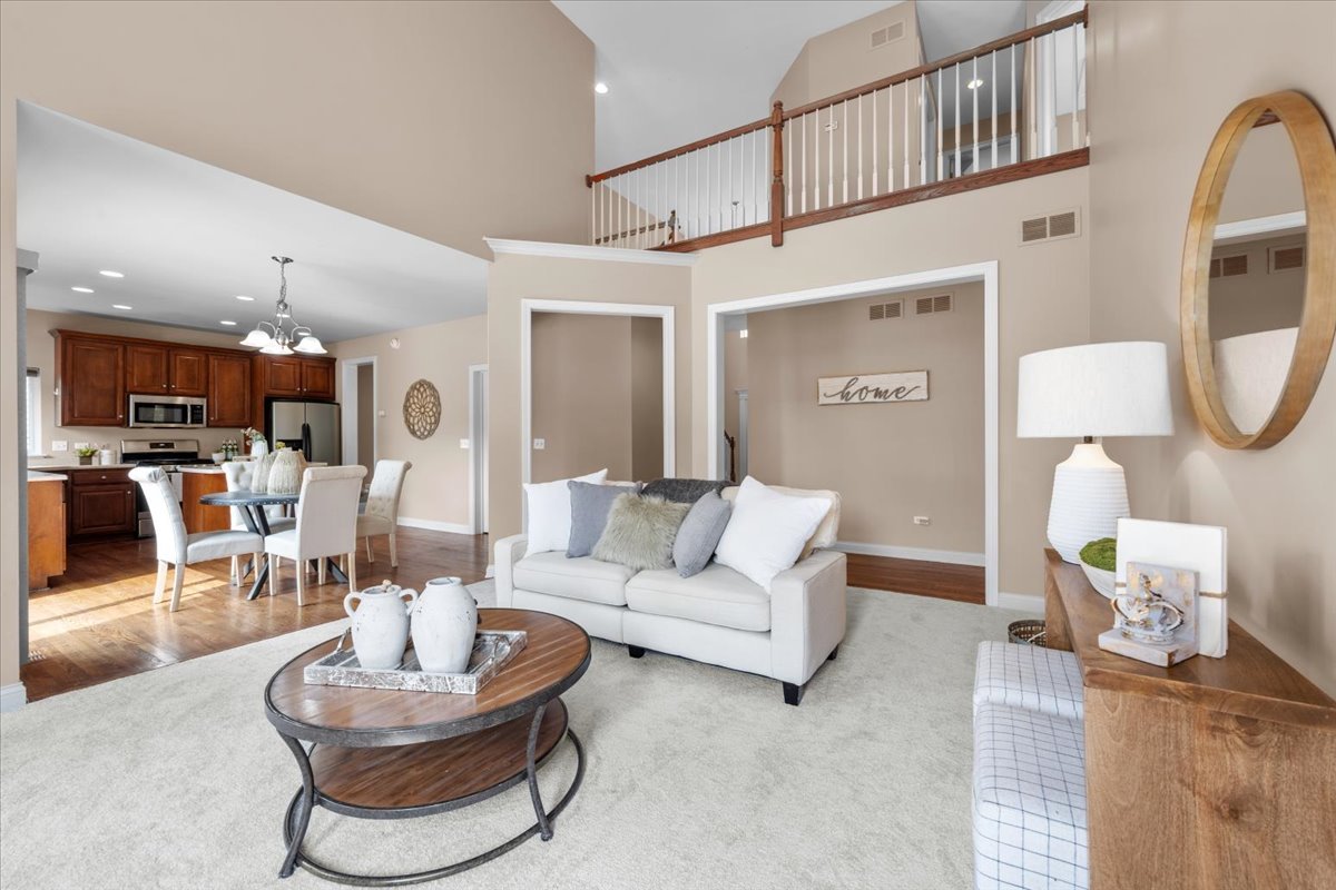1112 Stonehaven Circle Aurora, IL 60504 - Photo 8 of 28 a living room with furniture a lamp and a large window