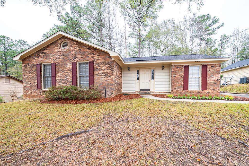 a front view of house with yard and trees around