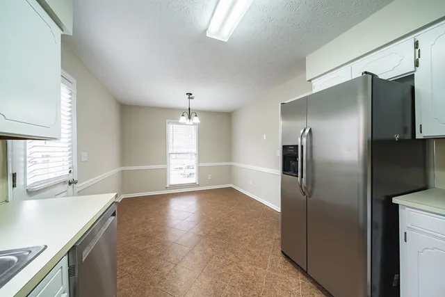 a view of a kitchen with a sink and refrigerator