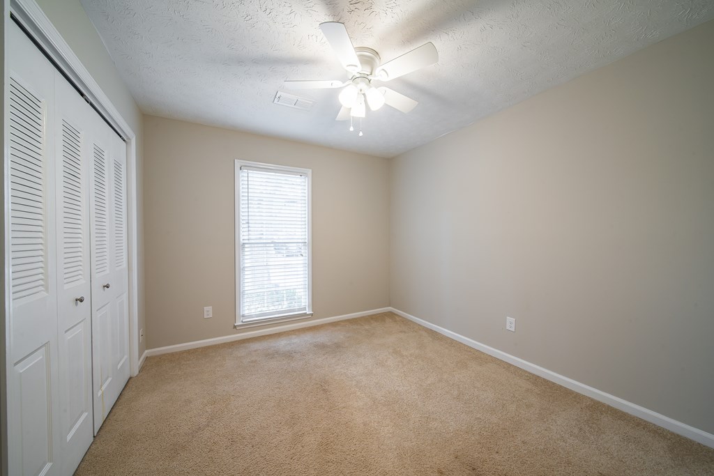 907 Eden Street Columbus, GA 31904 - Photo 19 of 26 an empty room with windows and chandelier fan