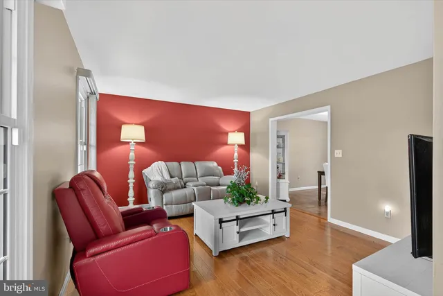 a living room with furniture wooden floor and lamp
