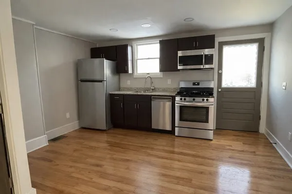 a kitchen with stainless steel appliances granite countertop a stove a refrigerator and a microwave