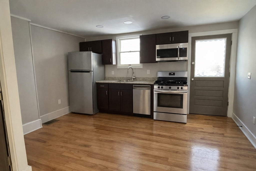 a kitchen with stainless steel appliances granite countertop a stove a refrigerator and a microwave