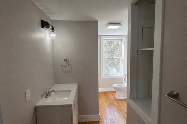 a bathroom with a toilet sink and mirror