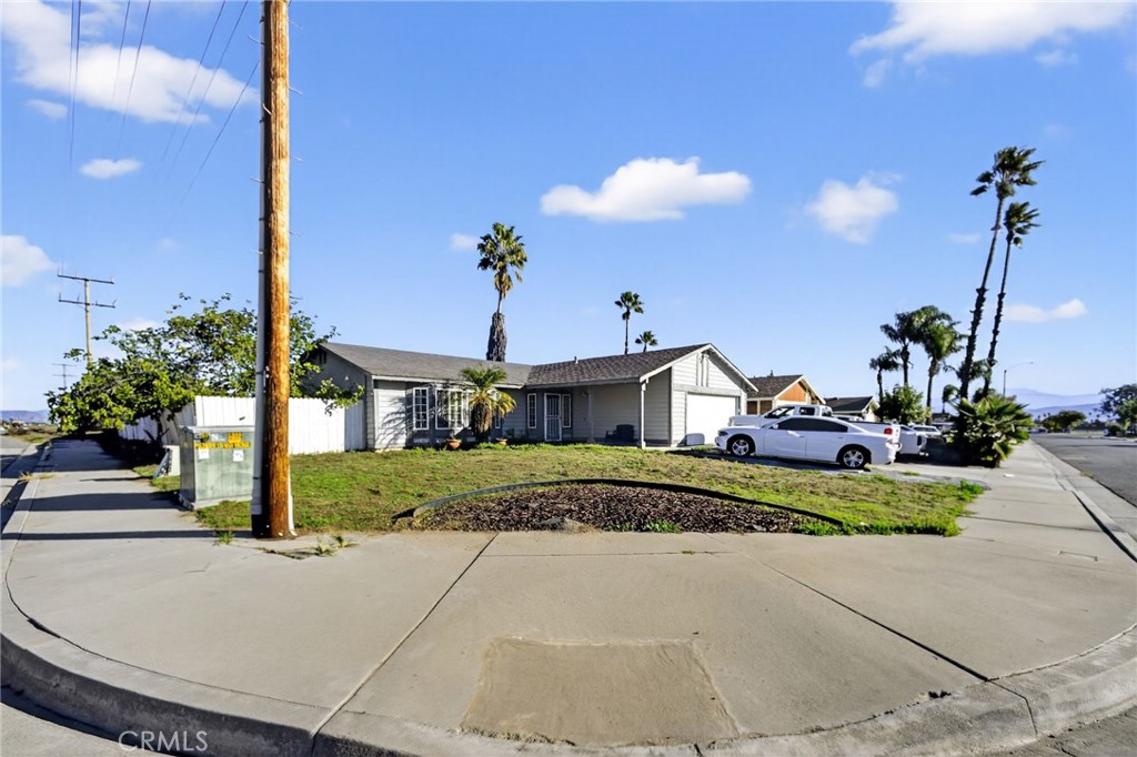 498 Serrana Road Perris, CA 92570 - Photo 3 of 8 a front view of a house with a yard and a garage