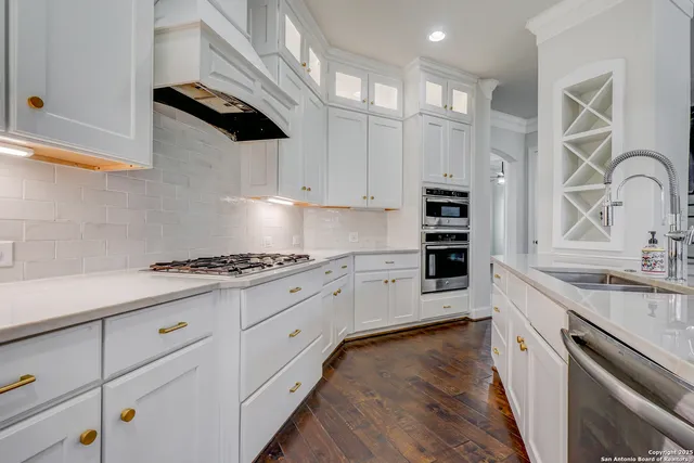 a large kitchen with stainless steel appliances granite countertop a lot of counter space and wooden floors