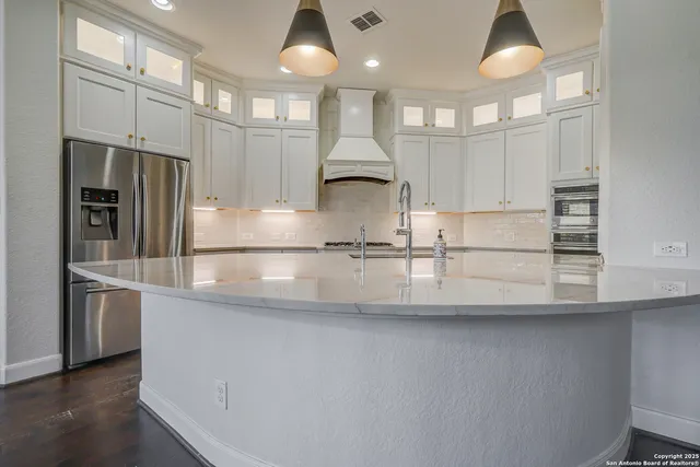 a kitchen with stainless steel appliances granite countertop a sink and a refrigerator