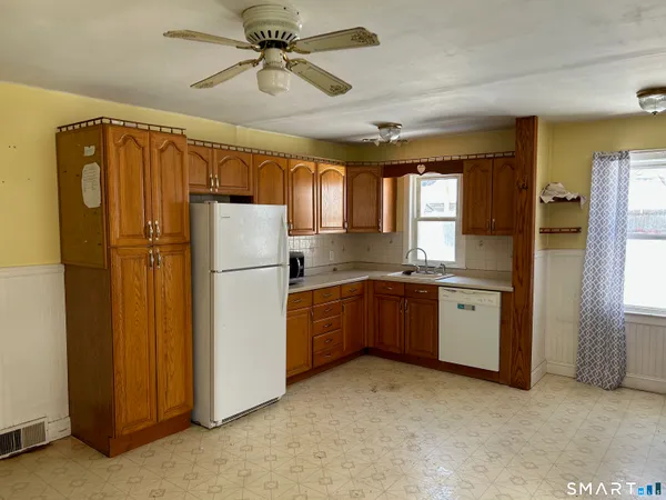 a kitchen with a refrigerator a sink and cabinets