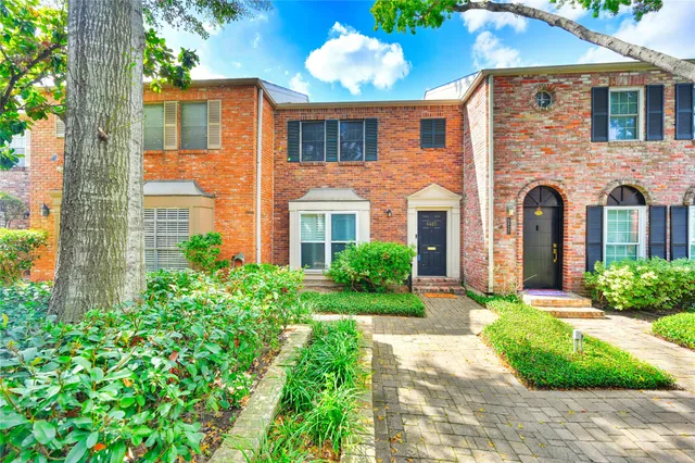 front view of a brick house with a yard