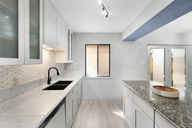a kitchen with granite countertop a sink and a window