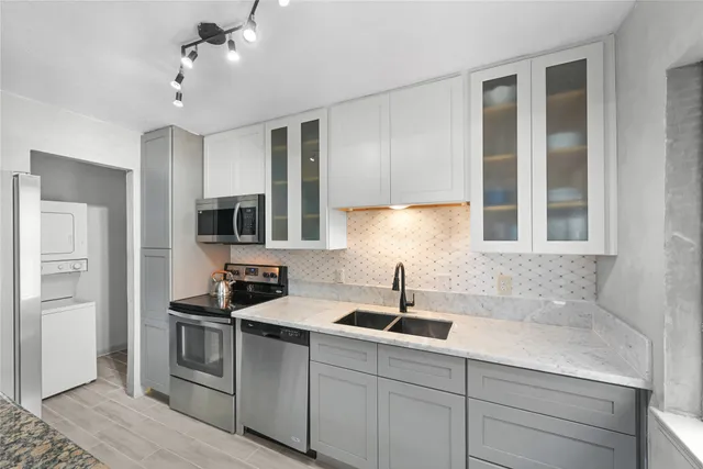 a kitchen with cabinets stainless steel appliances and a window
