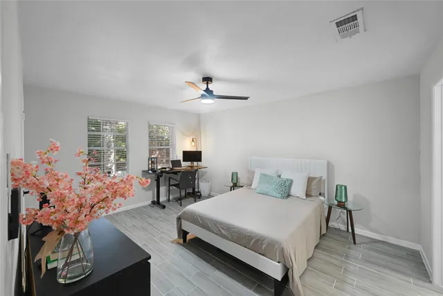 a bedroom with a large bed and a flat tv screen on dresser