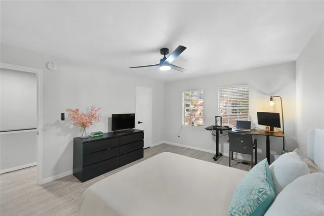 a living room with furniture a desk and a flat screen tv