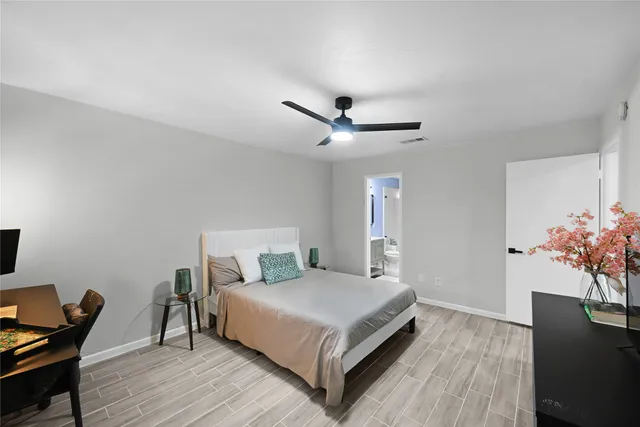 a bedroom with a bed wall painting and wooden floor