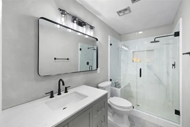 a bathroom with a toilet a sink and mirror