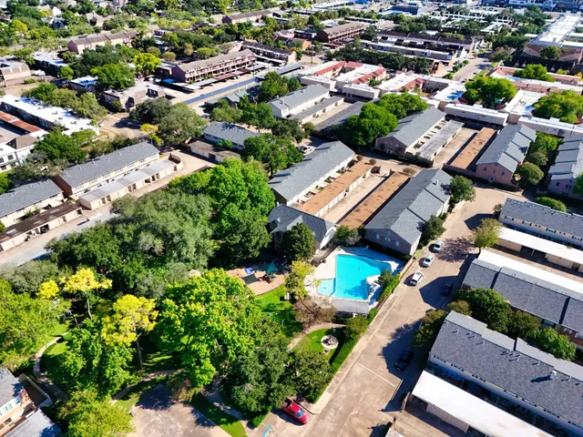 an aerial view of a residential houses with yard