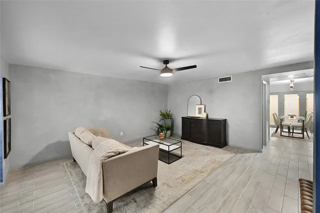 a living room with furniture and a wooden floor