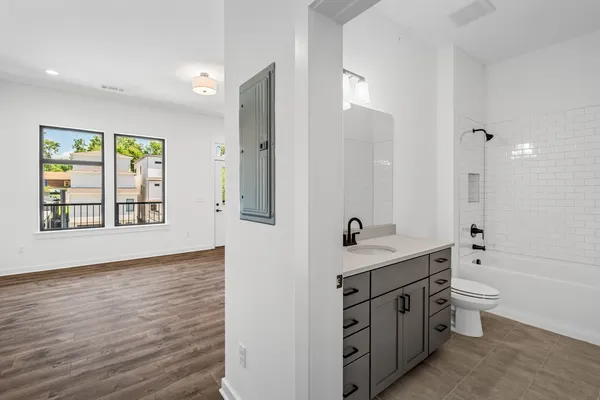 a bathroom with a granite countertop sink mirror and a bathtub