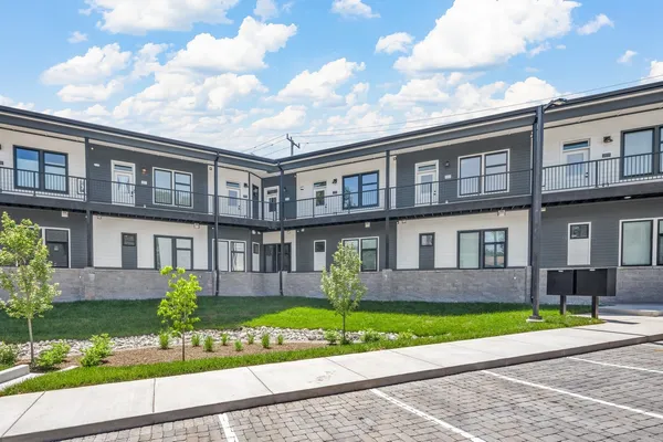a front view of a house with garden and parking