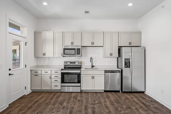 a kitchen with cabinets stainless steel appliances and a window