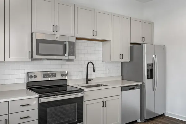 a kitchen with cabinets stainless steel appliances and a counter space