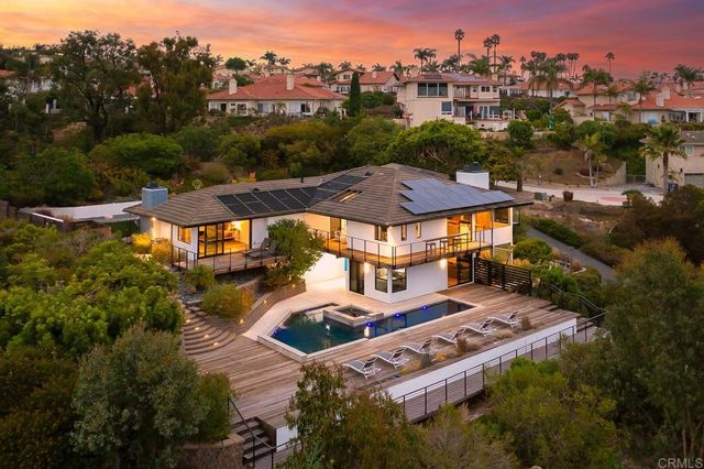 a view of a house with pool and chairs