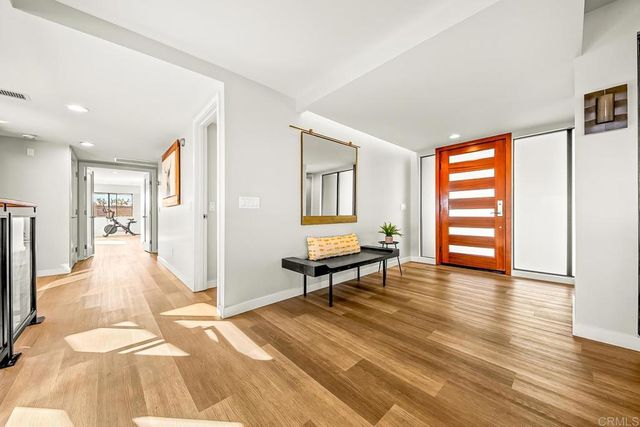 a view of a dining room with furniture a chandelier and wooden floor