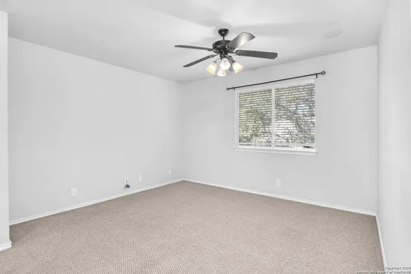 a view of a livingroom with a ceiling fan and window