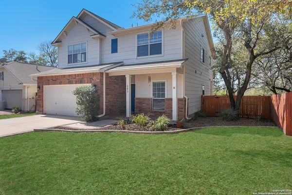 a front view of a house with a garden and yard