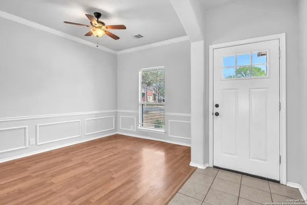 a view of an empty room with a window and wooden floor