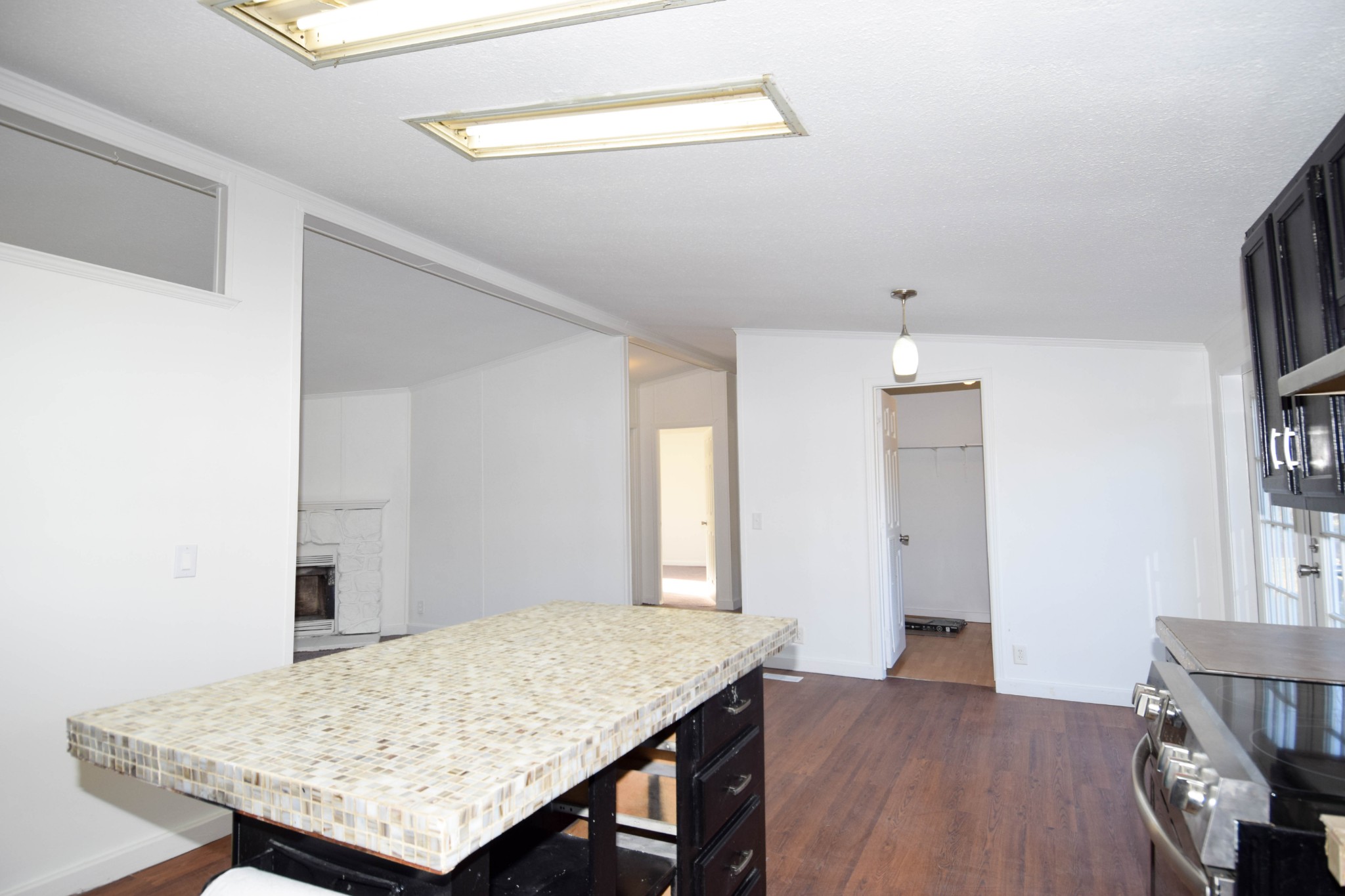 635 Celsor Road Hartsville, TN 37074 - Photo 18 of 44 a view of a kitchen that has a kitchen island a stove a wooden floor and a sink