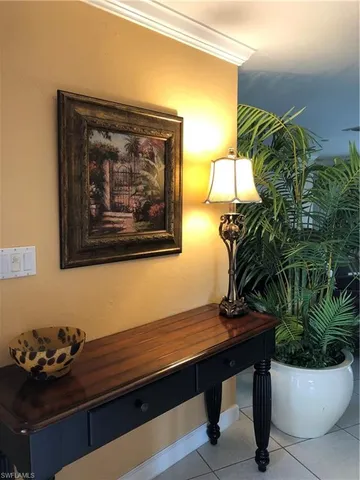a room with painting on the wall and a potted plant