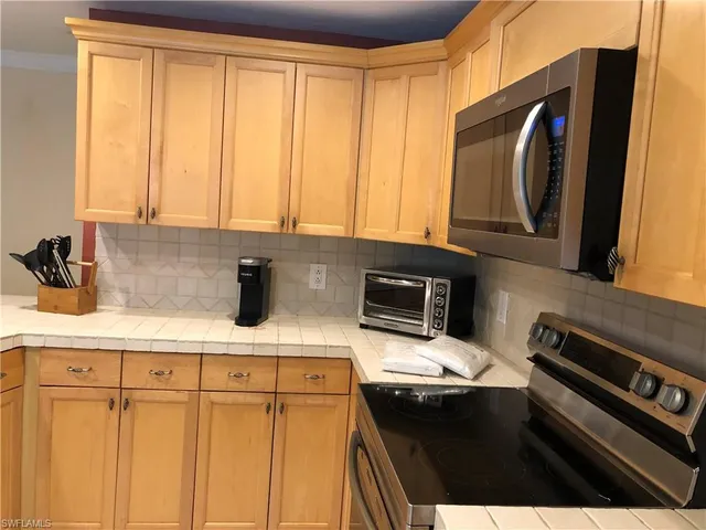 a kitchen with a sink a stove and cabinets